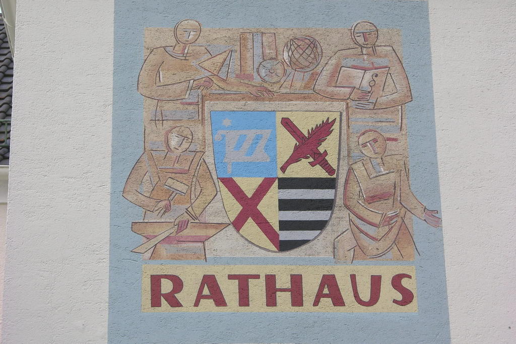 Restaurierung des sehr verblassten Fassadengemäldes mit Wappen und Schrift